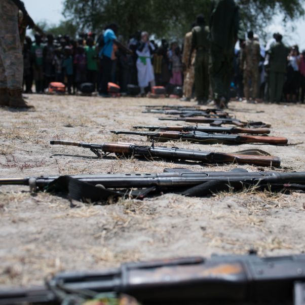 Children associated with the Cobra faction wait to be demobilized in Pibor, South Sudan; their weapons are seen on the ground. 26 October 2016. © UNICEF/UN037269/Lomodong