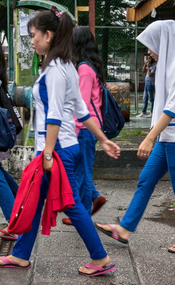 A group of young women migrant workers make their way through back alleys to get to work at a nearby hi-tech factory facility, Petaling Jaya, Malaysia, 28 November 2017. © UN Women