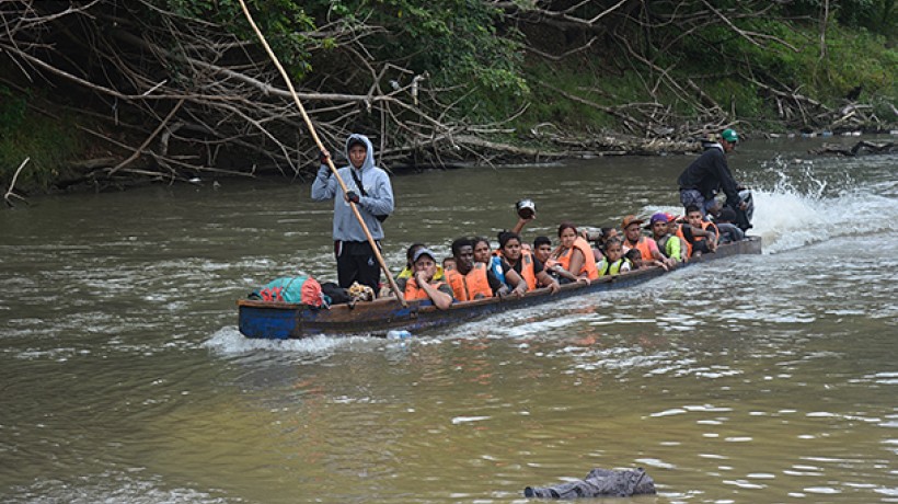 A boat arrives with migrants making the final crossing to the intake center in Panama. Many of the boats are piloted by indigenous people, who have stopped doing necessary work to cater to the migrants.  