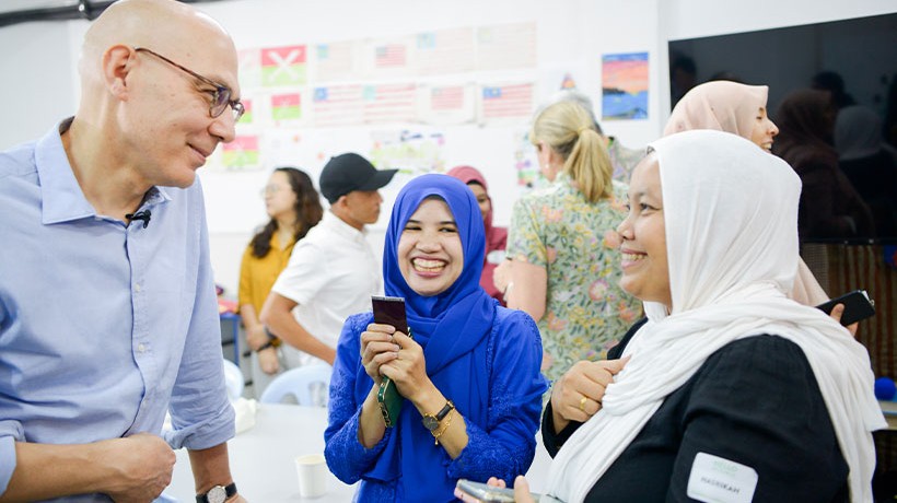 Volker Turk, UN High Commissioner for Human Rights, engaged in conversation with refugees and migrants during the potluck event. © Dari Dapur