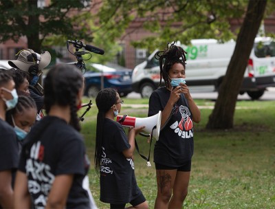 Still of Bianca Jones as she stands alongside youth organizers in Douglass Park addressing a crowd who has come to show support for the park renaming at their Campaign Relaunch Rally on July 18, 2020. © Kaleb Autman 