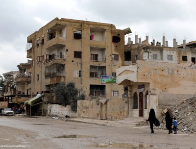 Two Syrian women walk next to destroyed buildings in central Raqqa city, Syria, 31 March 2019. © EPA-EFE/AHMED MARDNLI 