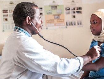 A doctor examines a young patient. © Getty Images