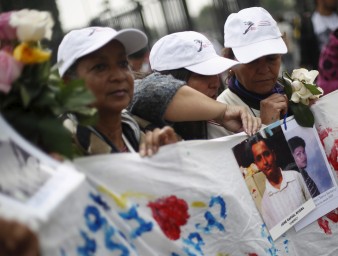 Women of the Caravana de Madres Centroamericanas (Caravan of Central American Mothers) hold up photos of missing migrants. © REUTERS/Edgard Garrid