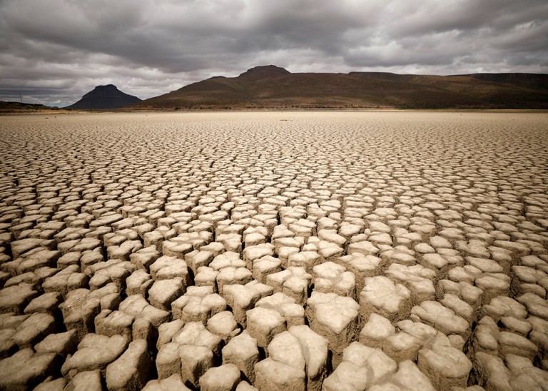 Clouds gather above earth cracks in a dried up dam in Graaff-Reinet, South Africa © REUTERS/Mike Hutchings, November 14, 2019.