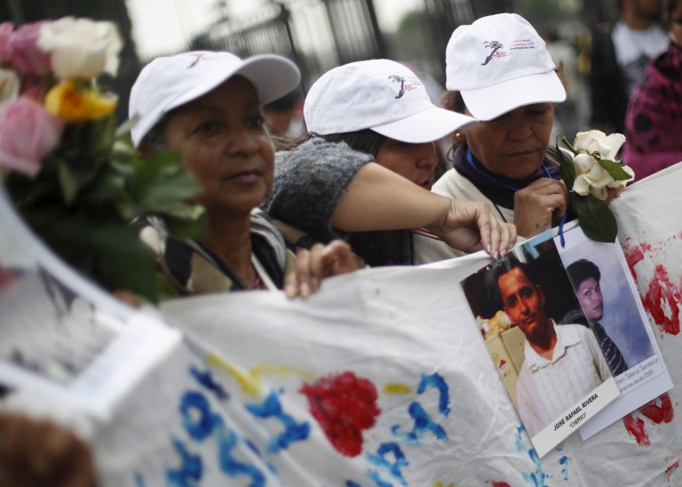 Women of the Caravana de Madres Centroamericanas (Caravan of Central American Mothers) hold up photos of missing migrants. © REUTERS/Edgard Garrid