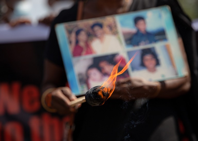 Relatives of the disappeared hold pictures of loved ones during a demonstration.© Kumanan Kanapathippillai