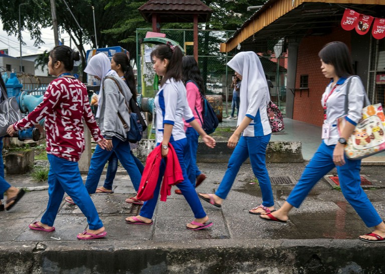 A group of young women migrant workers make their way through back alleys to get to work at a nearby hi-tech factory facility, Petaling Jaya, Malaysia, 28 November 2017. © UN Women